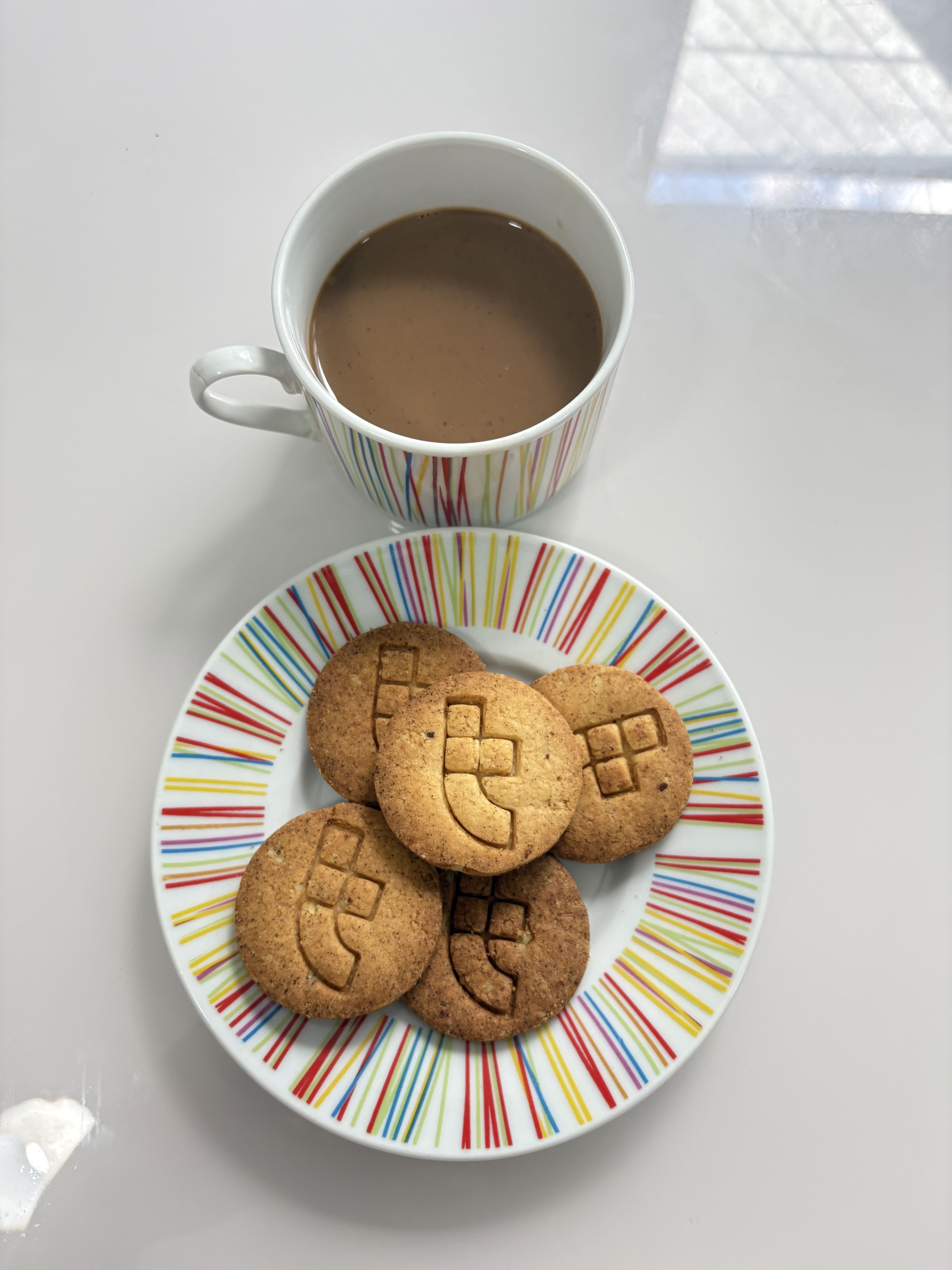 Coffe Toglab A stylish cup of coffee paired with custom cookies featuring the Toglab logo.